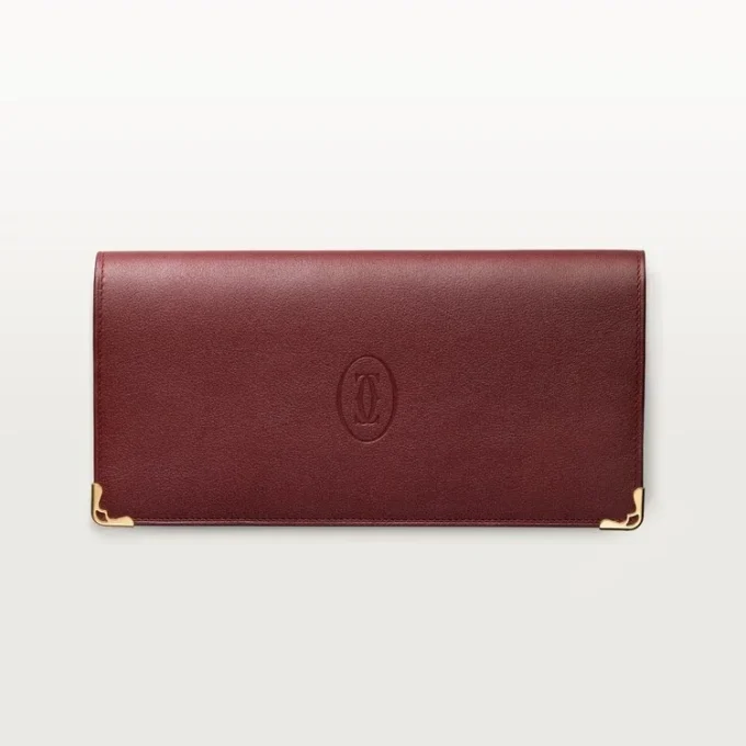 Cartera internacional con fuelles, Must de Cartier – Piel de becerro burdeos, acabado dorado – Cartier