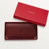 Cartera internacional con fuelles, Must de Cartier – Piel de becerro burdeos, acabado dorado – Cartier
