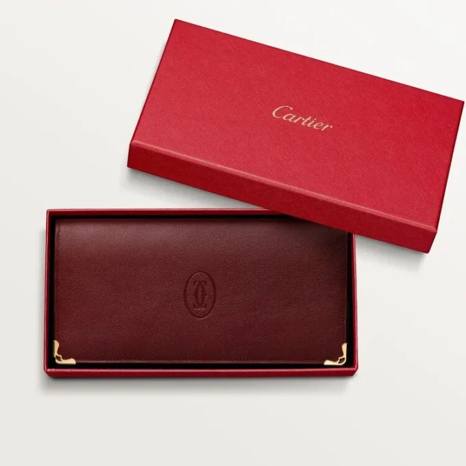 Cartera internacional con fuelles, Must de Cartier – Piel de becerro burdeos, acabado dorado – Cartier